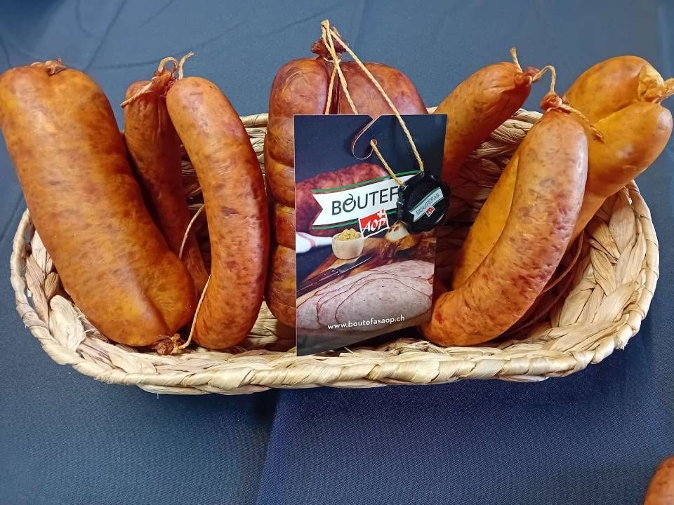 Un panier de saucisses avec une carte sur laquelle est écrit Boutefa