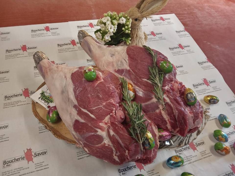 Deux morceaux de viande crue décorées d'herbes aromatiques sont posés sur un papier.