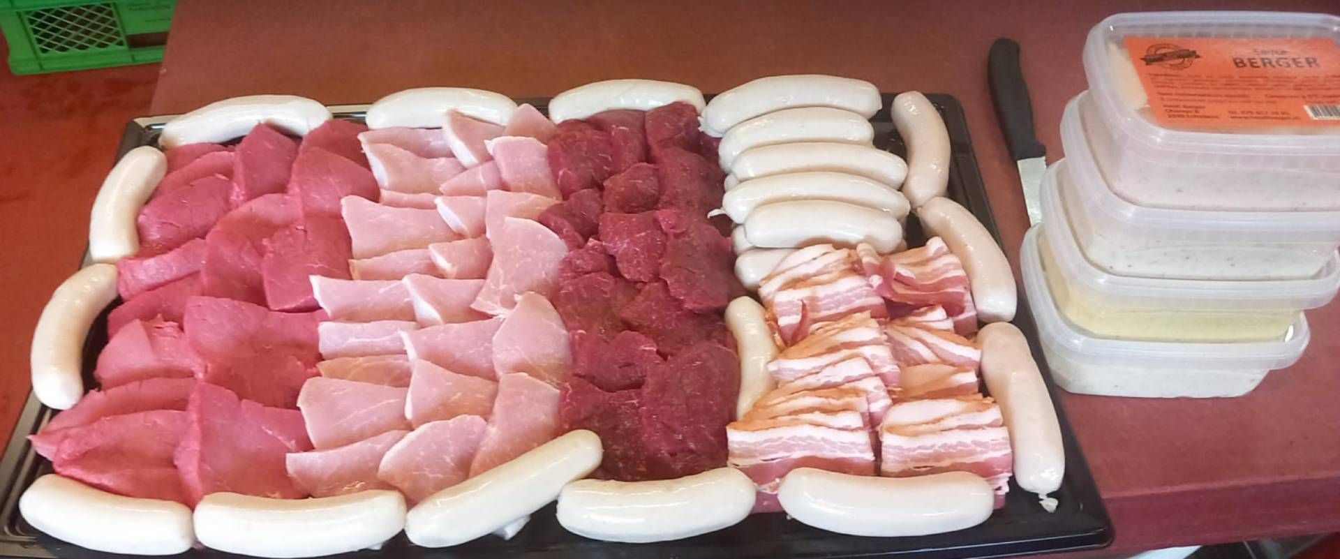 Différentes viandes et saucisses présentées sur un plateau.