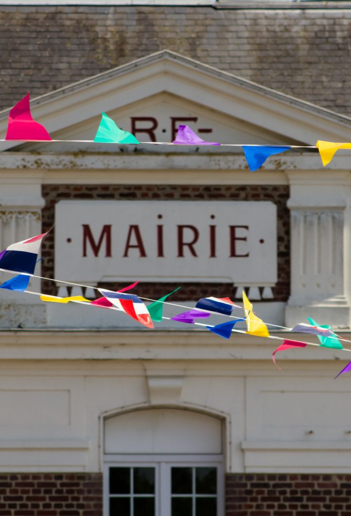 Bâtiment Mairie orné de fanions colorés et portant l'inscription.