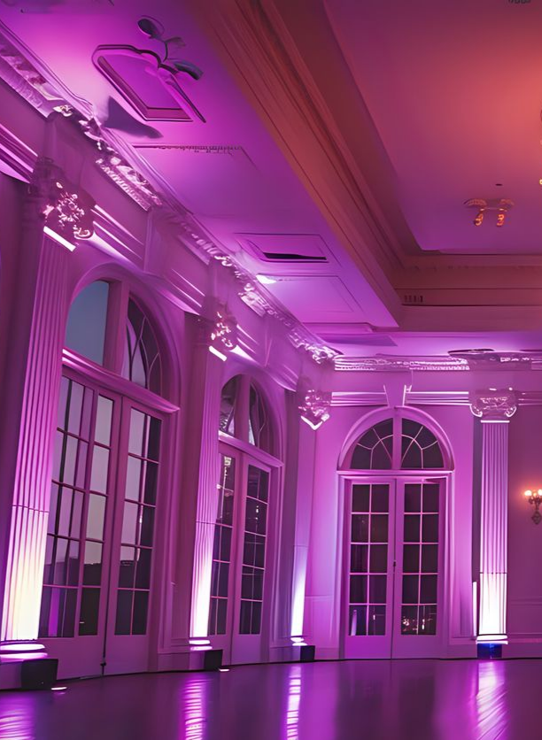 Élégante salle de bal avec portes cintrées, piliers et éclairage rose.