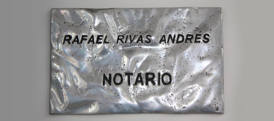 A metal sign that says rafael rivas andres notario