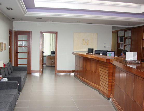 Una sala de espera con un mostrador de madera y un sofá.