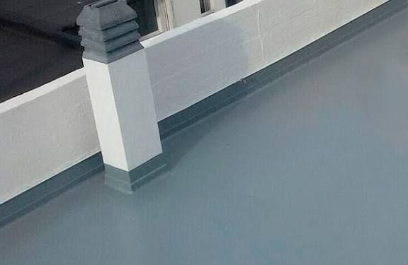 Cubierta y pared pintadas de gris con un pilar blanco y moldura gris oscuro.