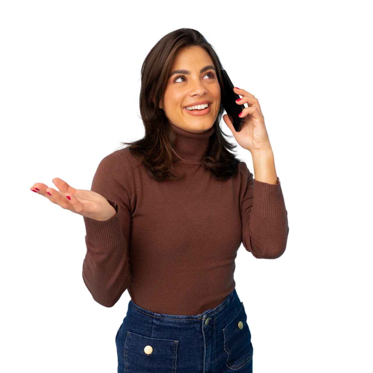 Une femme vêtue d'un col roulé marron et d'un jean bleu sourit en parlant au téléphone.