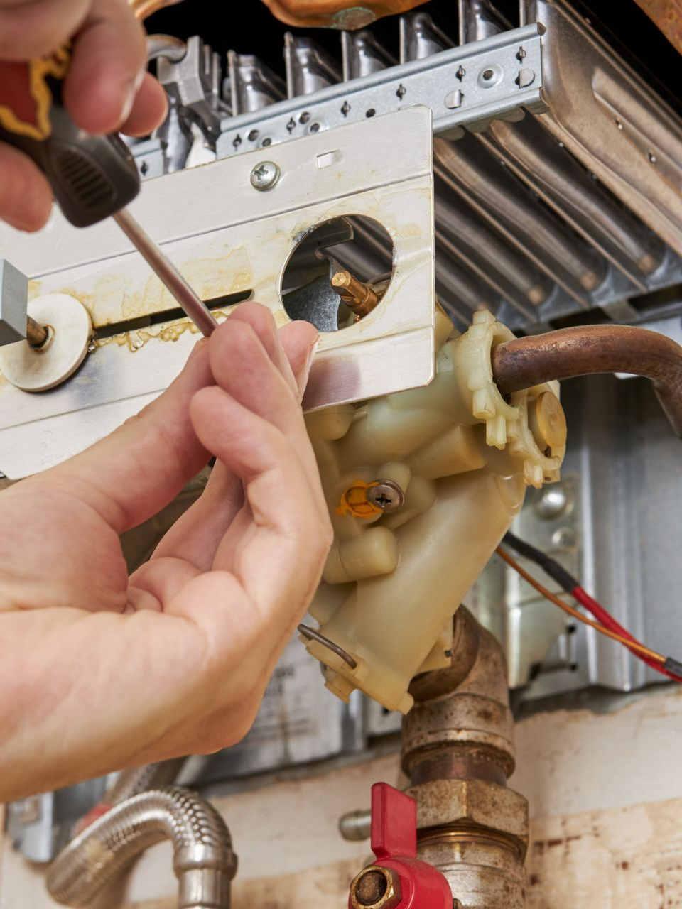 Une personne utilise un tournevis pour travailler sur un composant.