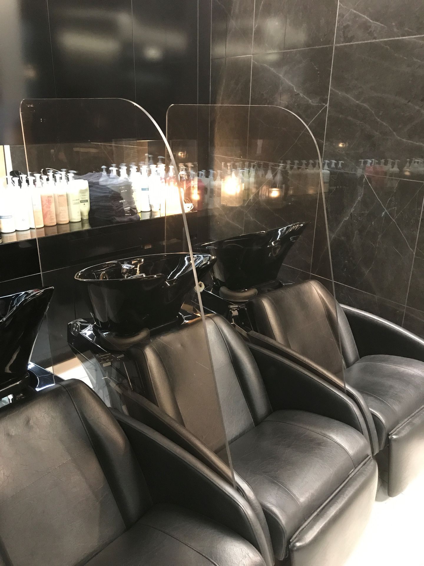 Éléments de vitrage entre des sièges d'un salon de coiffure