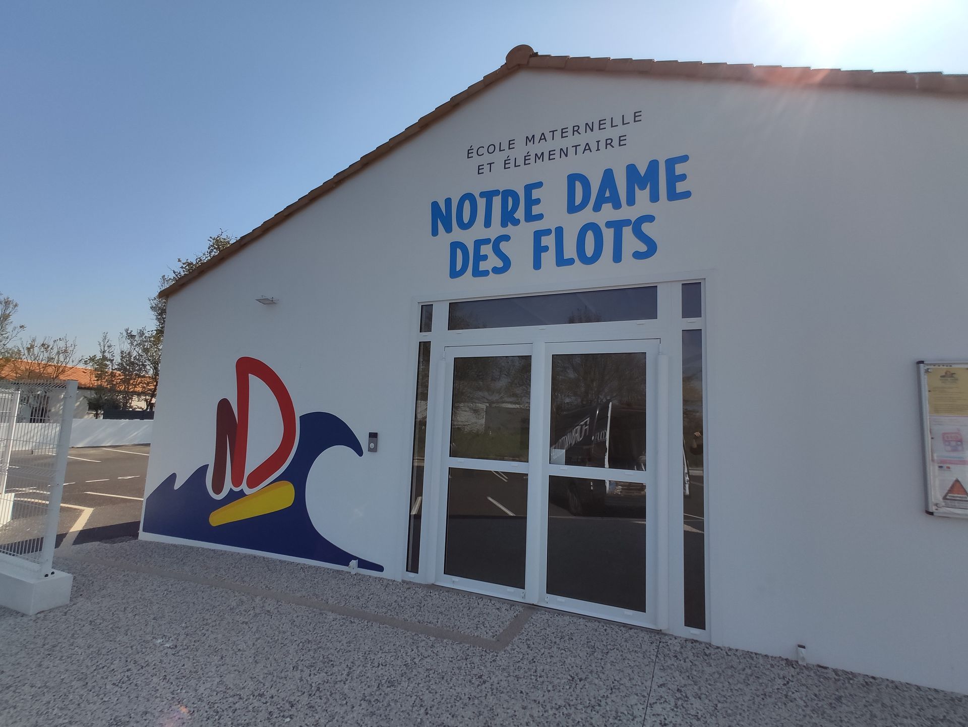 Un panneau directionnel blanc avec l'inscription OFFICE DE TOURISME en caractères noirs et une icône d'information, monté sur un poteau en métal foncé.
