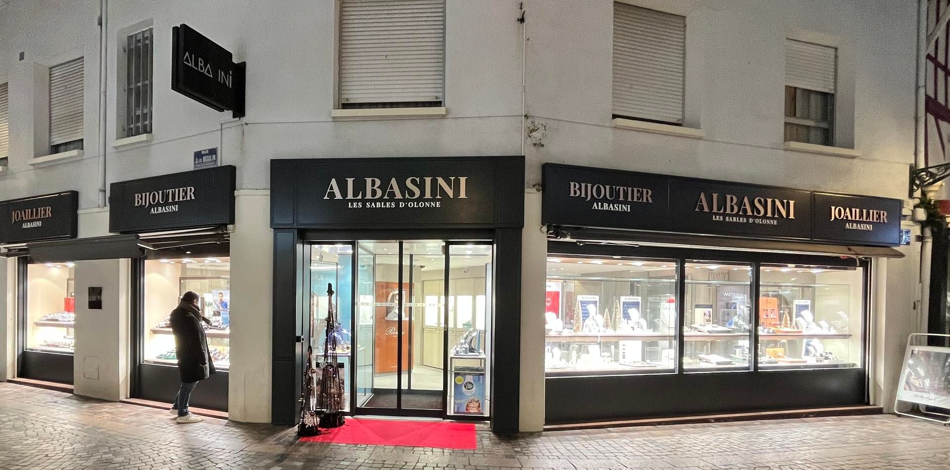 Façade moderne d'un bâtiment avec un mur incurvé de lattes verticales brunes, portant l'enseigne Le Comptoir la Sablaise.