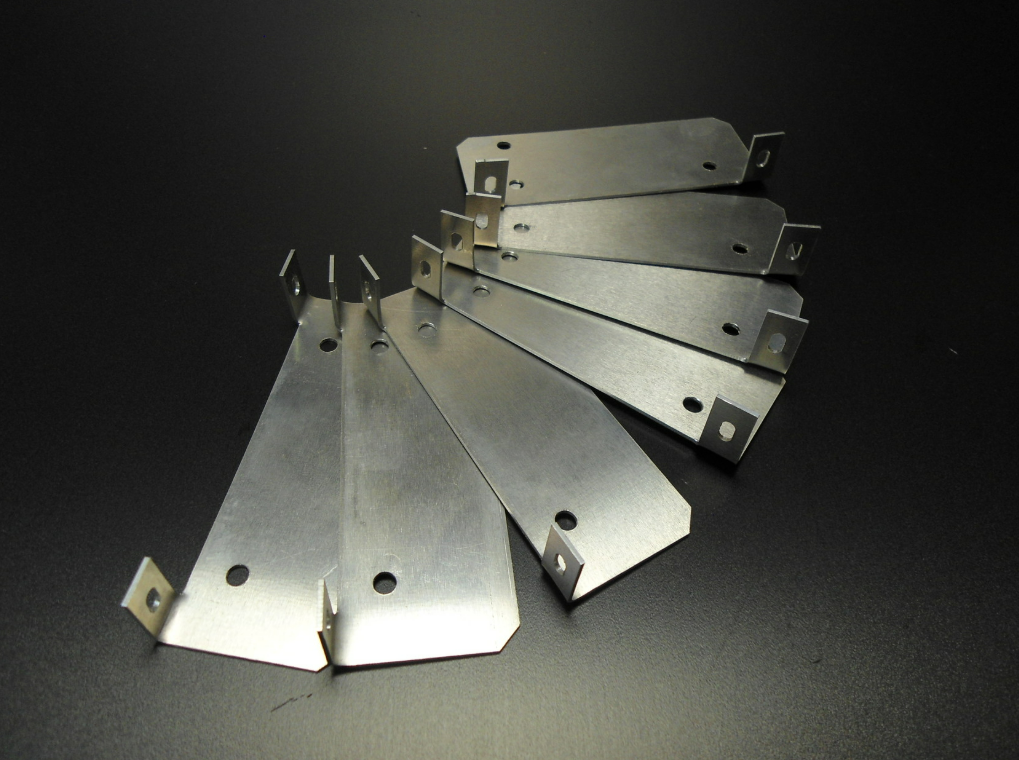 Un ensemble de supports métalliques en forme d'éventail, disposés en motif circulaire sur un fond sombre.