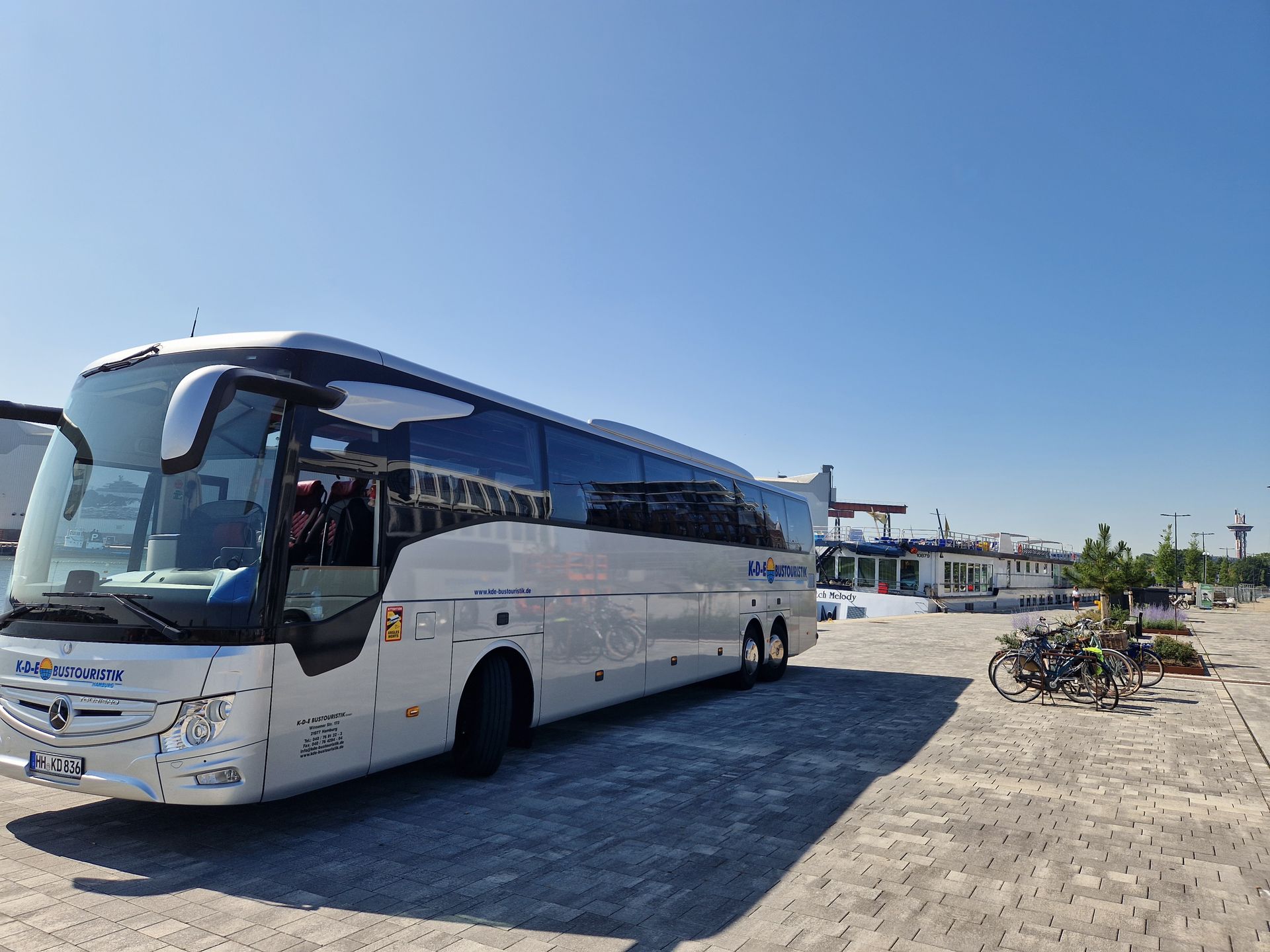 Ein großer weißer Bus steht auf einem Parkplatz.