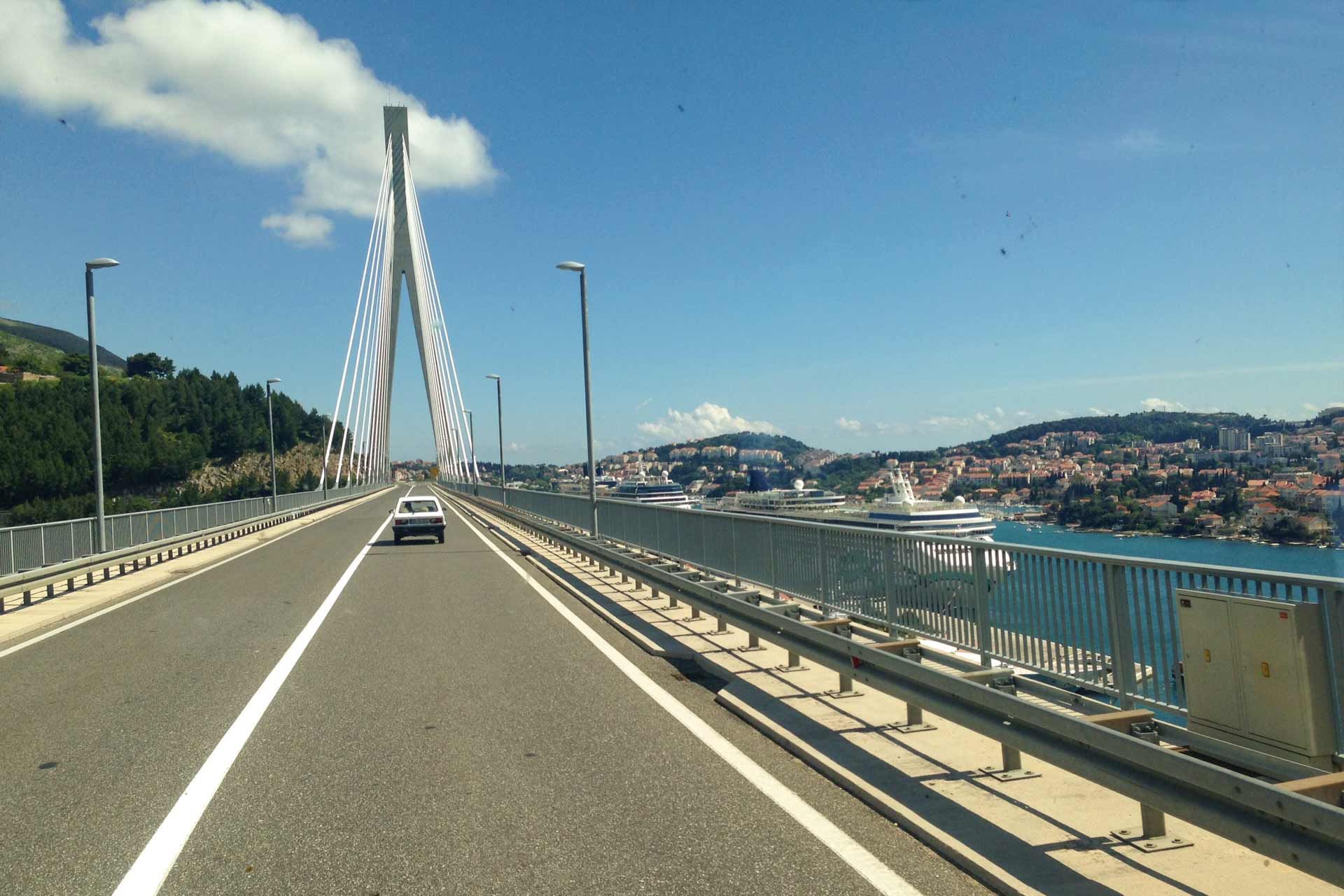 Ein Auto fährt auf einer Brücke über ein Gewässer