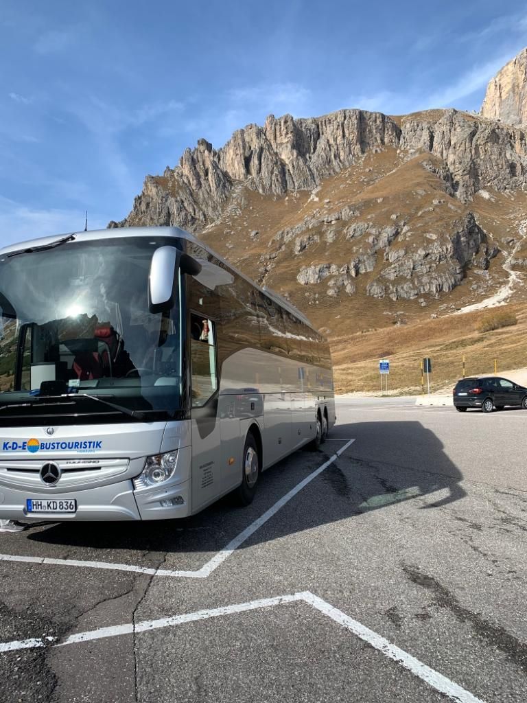 Ein Bus steht auf einem Parkplatz vor einem Berg.