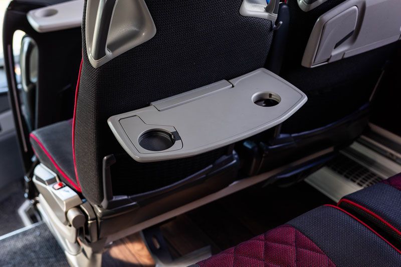 Das Innere eines Busses mit roten und grauen Sitzen.