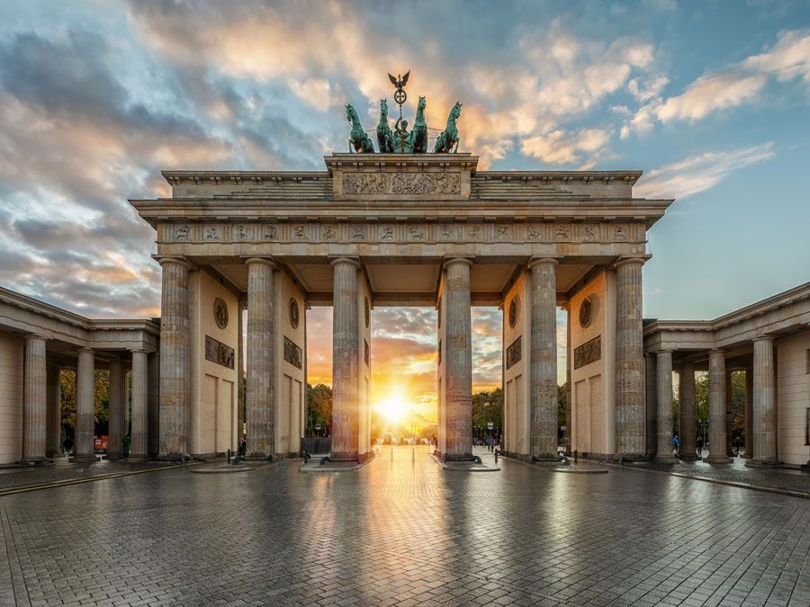 Die Sonne scheint bei Sonnenuntergang durch das Berliner Tor.