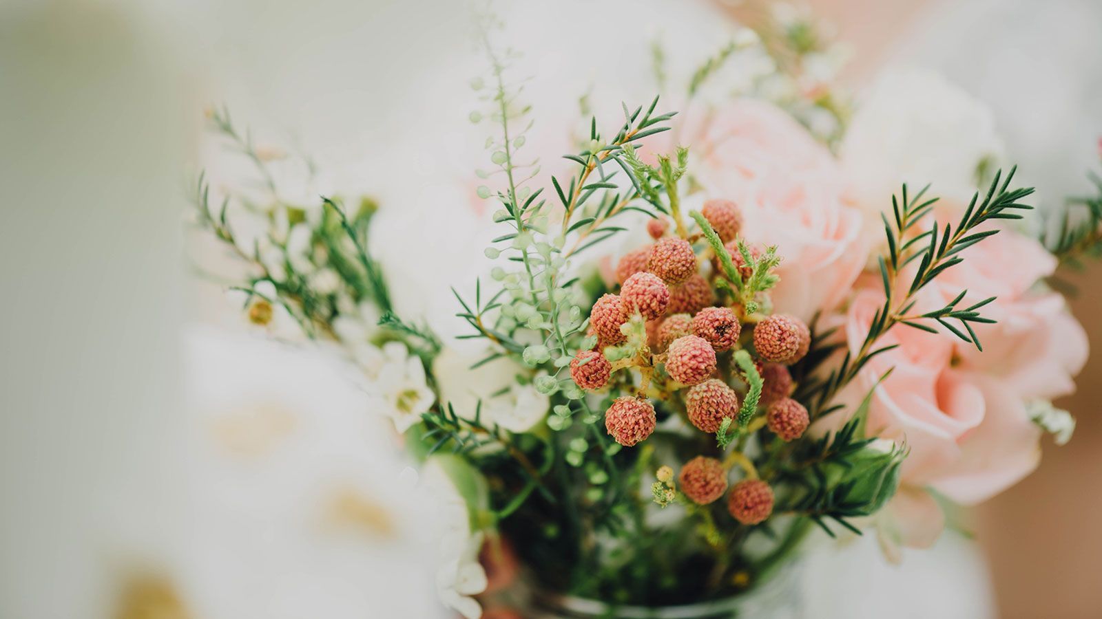 Eine Nahaufnahme einer Vase voller rosa und weißer Blumen.