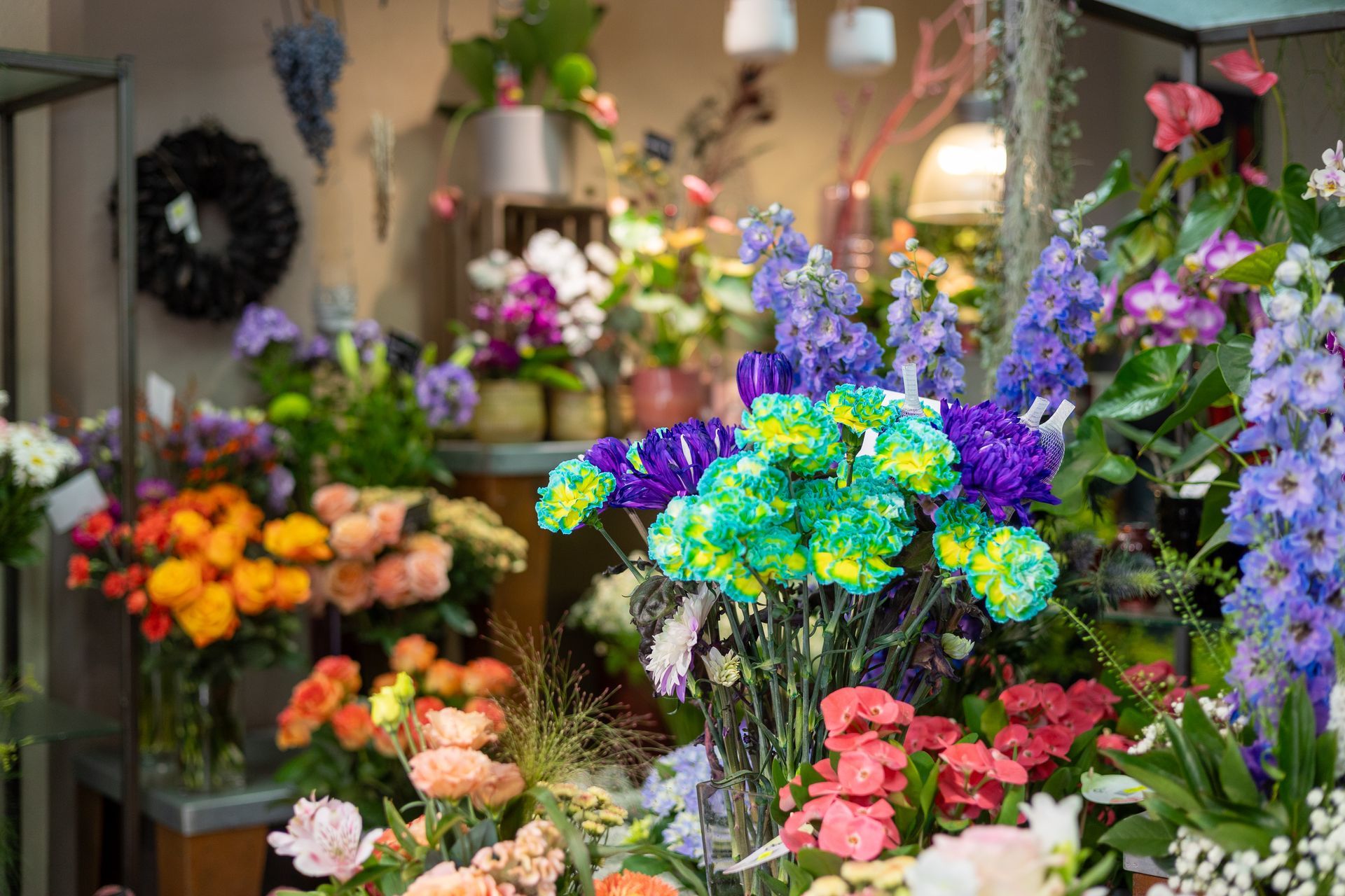 Bunte Blumensträuße in einem Geschäft, wobei rosa, lila, gelbe und grüne Blüten den Vordergrund füllen