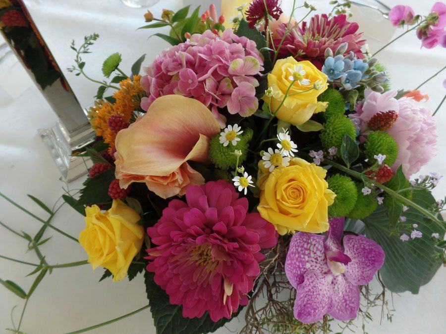 Bunter gemischter Blumenstrauß mit gelben Rosen, rosa Blüten und einer orangefarbenen Calla-Lilie