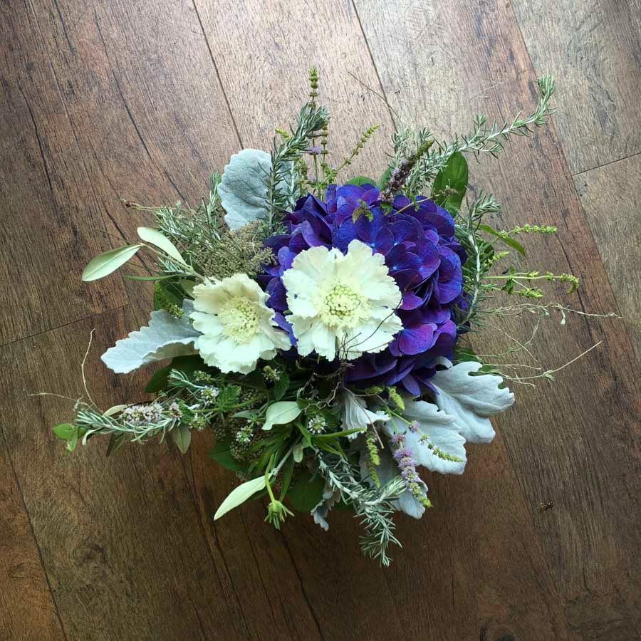 Weißer und violetter Blumenstrauß auf einer Holzoberfläche