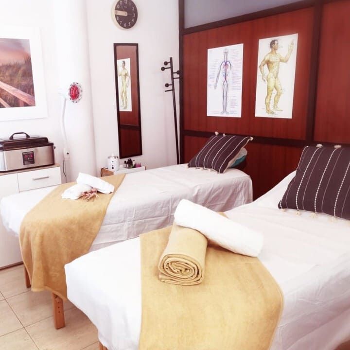Una habitación con dos camas y un reloj en la pared.
