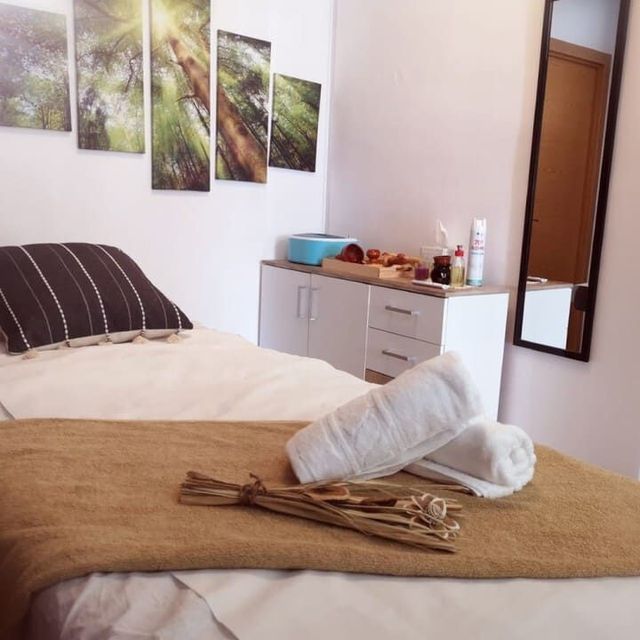 Un dormitorio con una cama y un espejo en la pared.