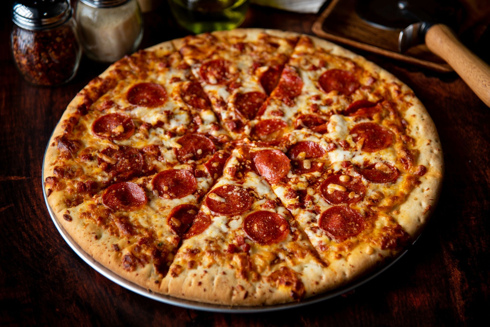 Pizza au pepperoni coupée en tranches sur un plateau en métal.