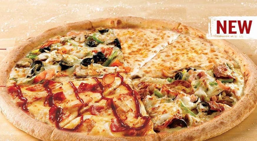 Pizza dans une boîte blanche, coupée en parts. Pepperoni, fromage et sauce visibles. Table en bois en arrière-plan.