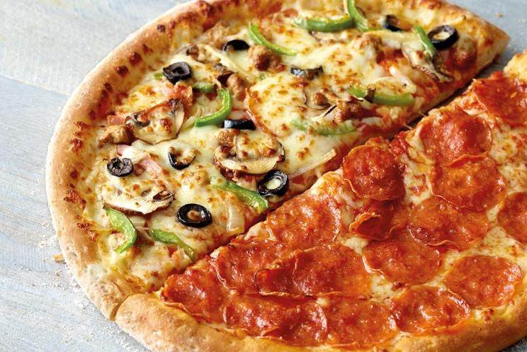 Pizza coupée en deux, avec garniture d'un côté et pepperoni de l'autre, logo Black Mama Pizza.