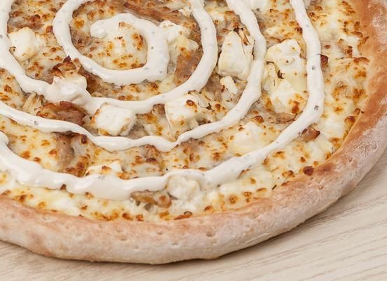 Pizza au fromage avec fromage bleu et noix, tranchée, sur une planche en bois.