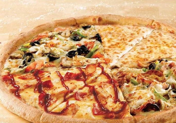 Quatre tranches de pizza sur un plateau en bois ; les garnitures comprennent de la mozzarella, du pepperoni, du prosciutto et de la sauce.