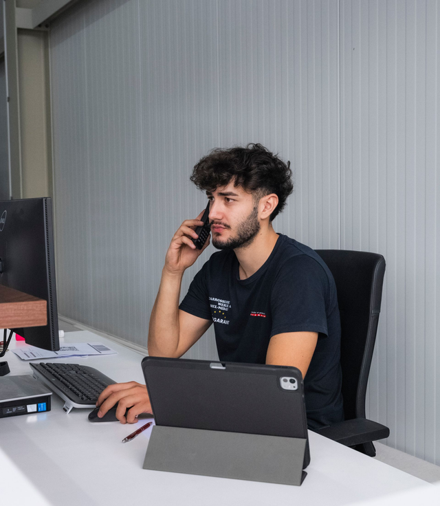 Eine Person im Schutzanzug bedient eine Maschine in einer sterilen Umgebung und ist an ein Beatmungsgerät angeschlossen.