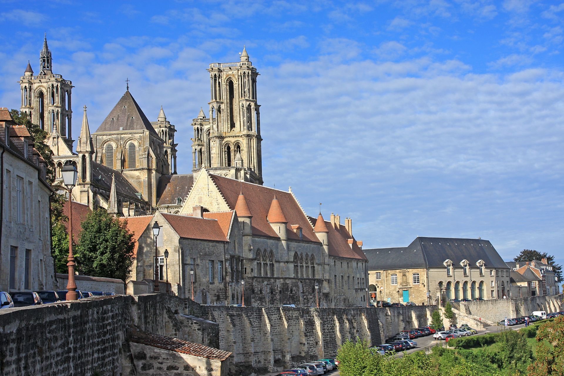 Cathédrale historique et bâtiments en pierre à flanc de colline sous un ciel bleu.