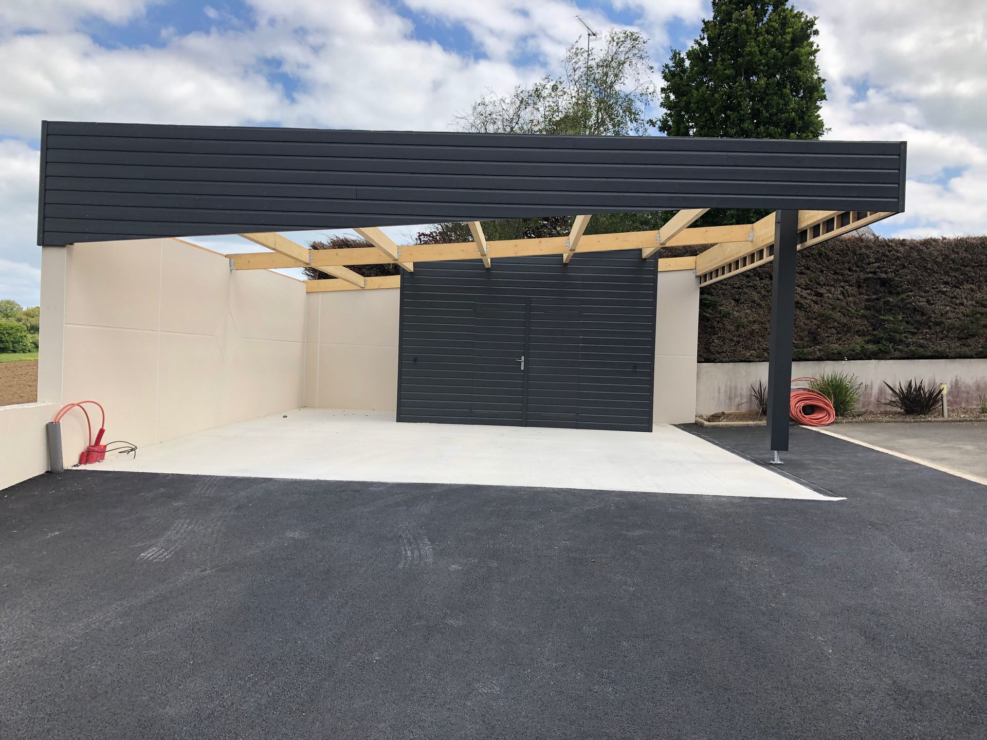 Espace de vie dans un jardin avec un muret en béton