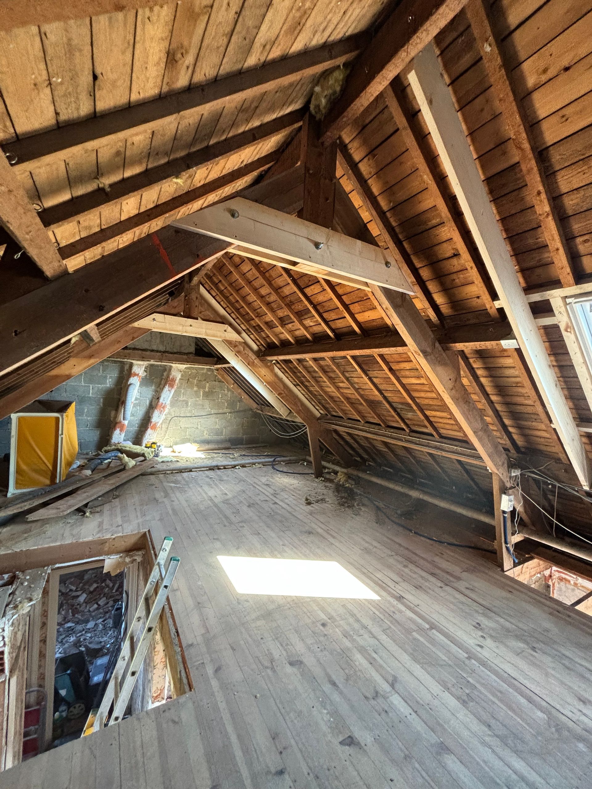Intérieur d'un grenier avec une charpente et des poutres en bois