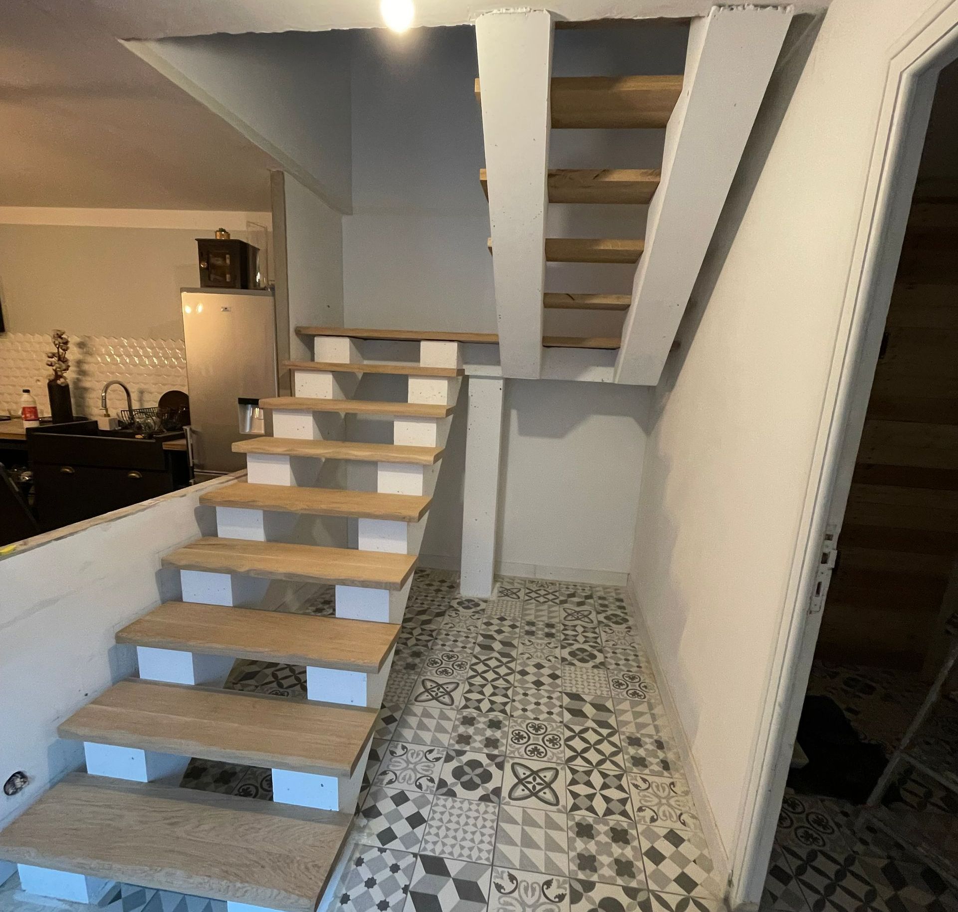 Double escalier avec sol en carrelage à motifs