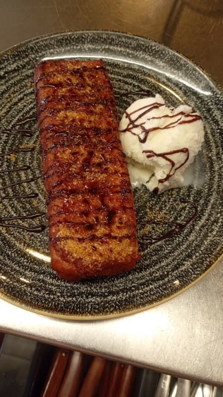 Filete de salmón a la parrilla en un plato con una porción de puré de patatas rociado con salsa.