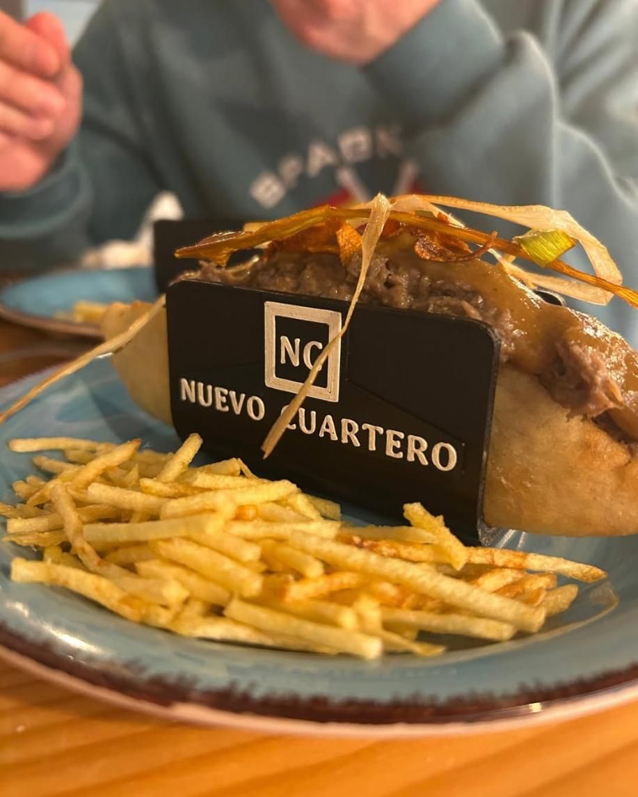 Hot dog envuelto en papel negro con texto 