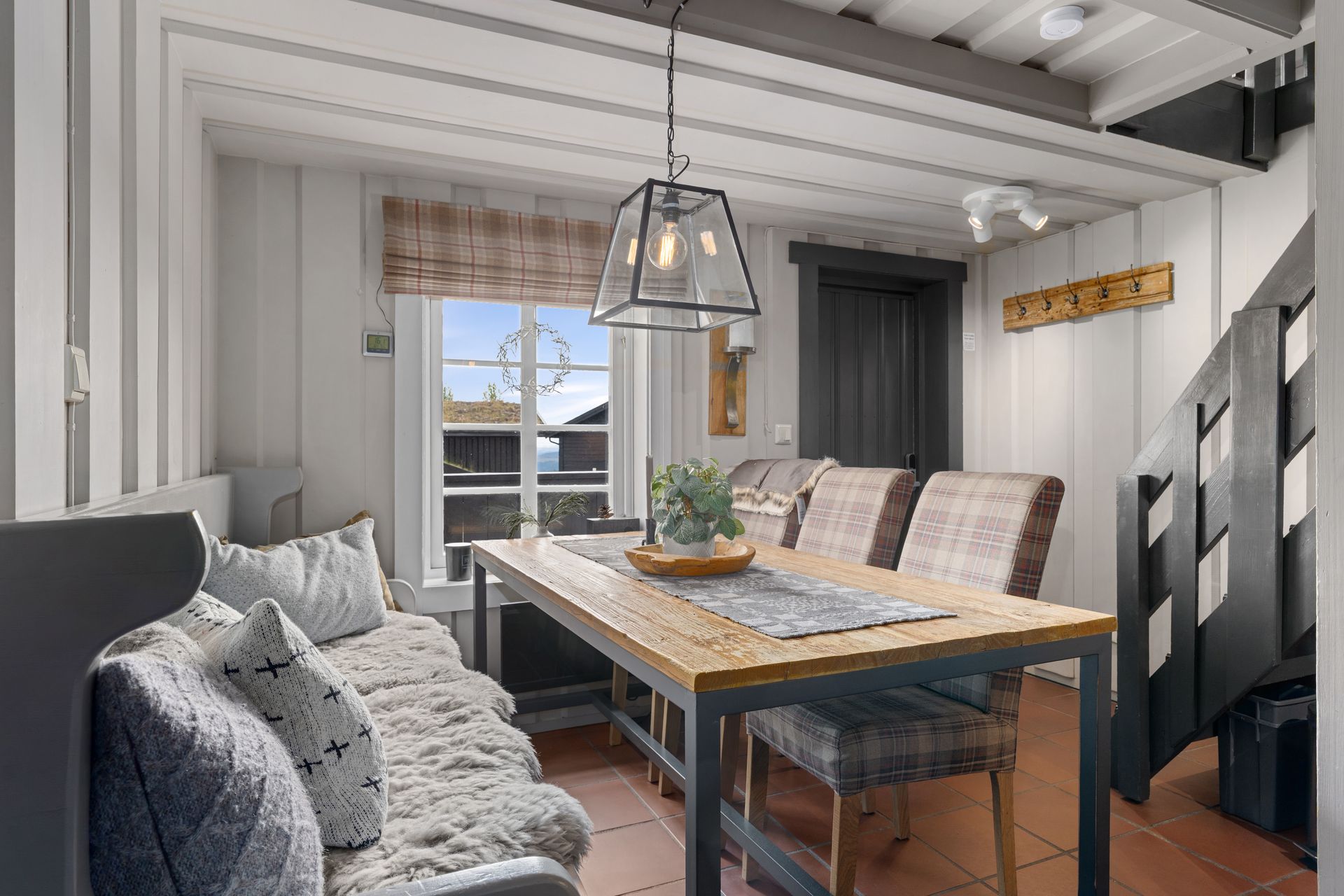 Cozy dining area with a wooden table, seating, and a window with a view.
