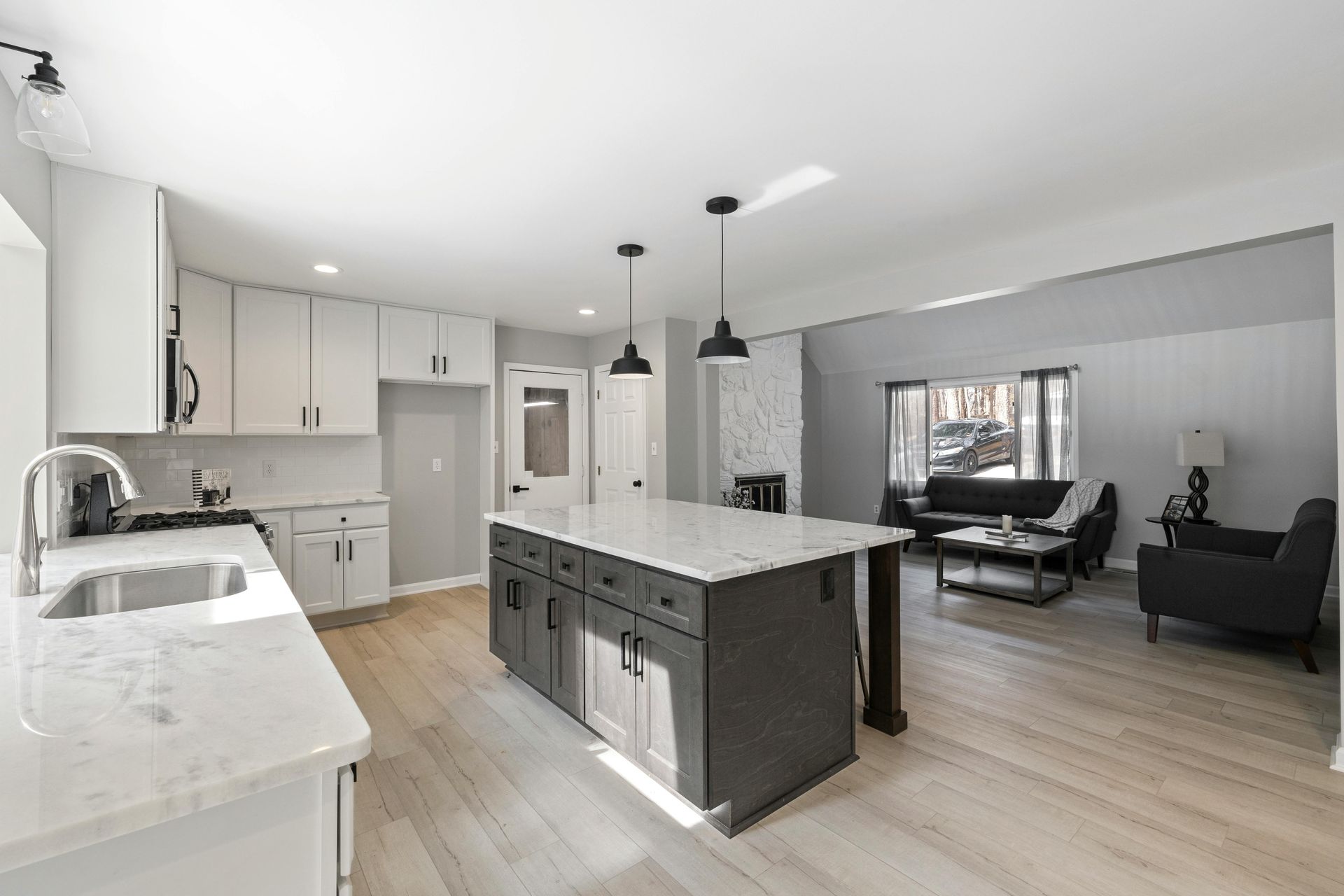 Interior de una habitación en construcción, con paredes blancas, techo sin terminar y herramientas esparcidas en el suelo.