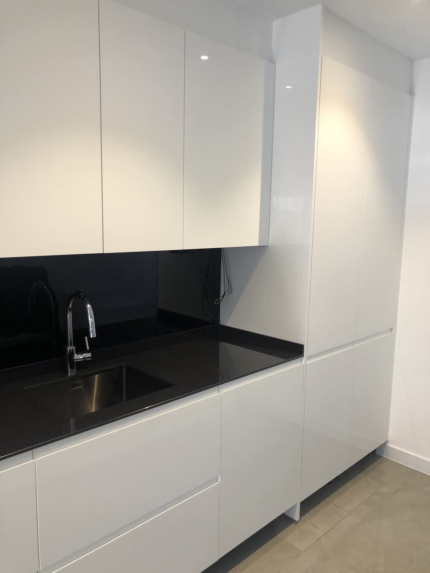 Gabinetes de cocina blancos y encimera negra con fregadero.