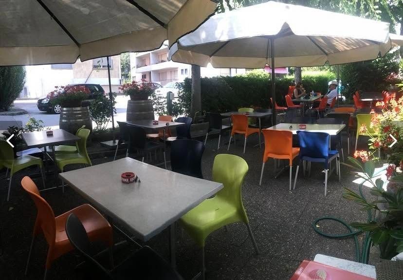 Terrasse de café avec tables, chaises colorées et grands parasols