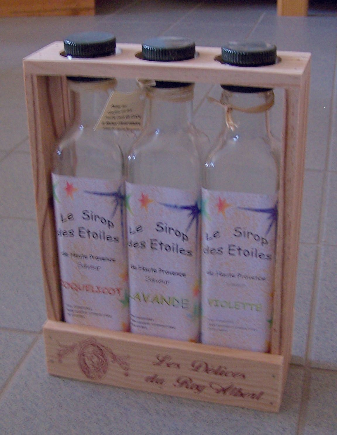 Photo d'un casier en bois avec trois bouteilles rangées