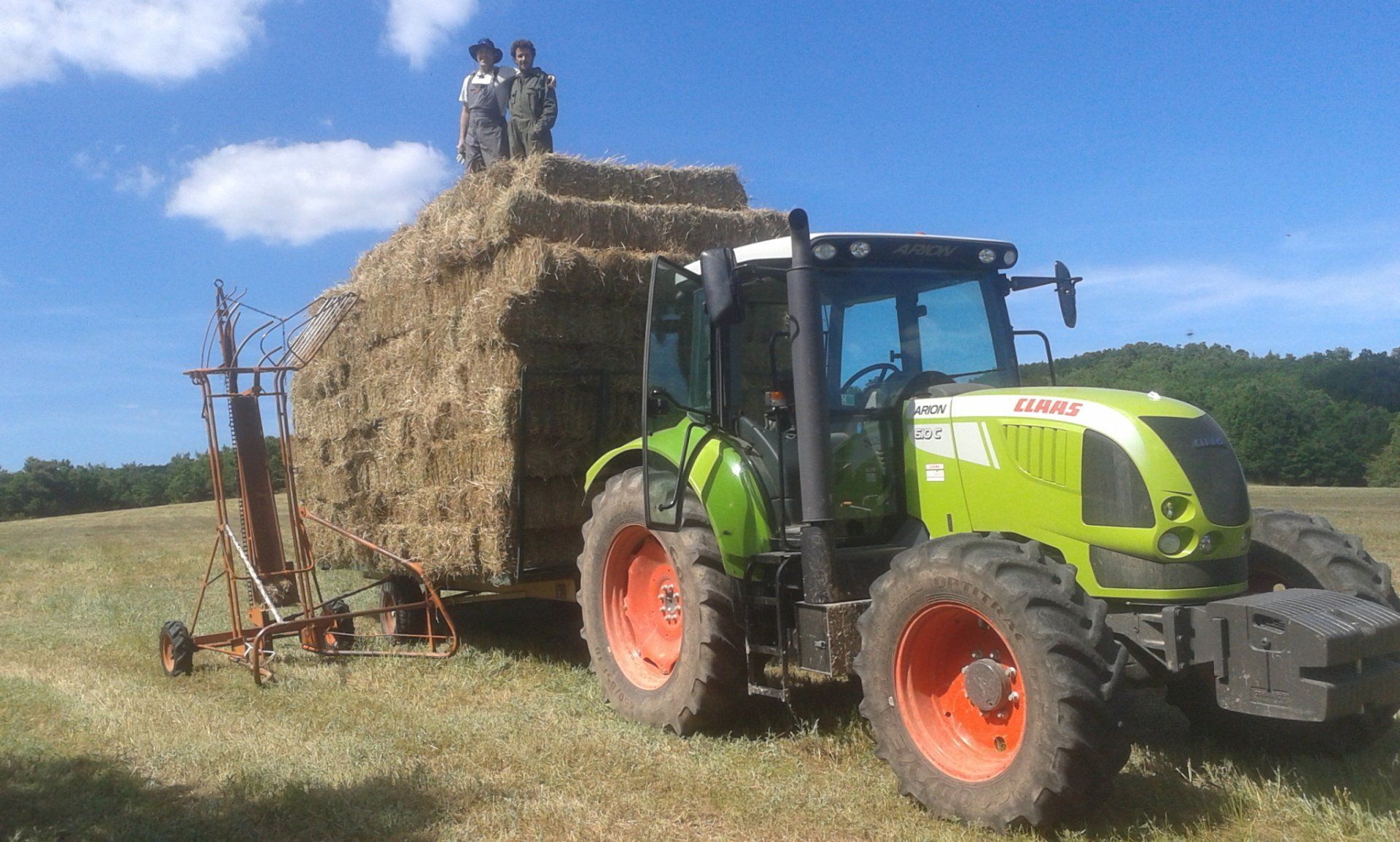 Photo d'un tracteur avec une remorque pleine de bottes de foin