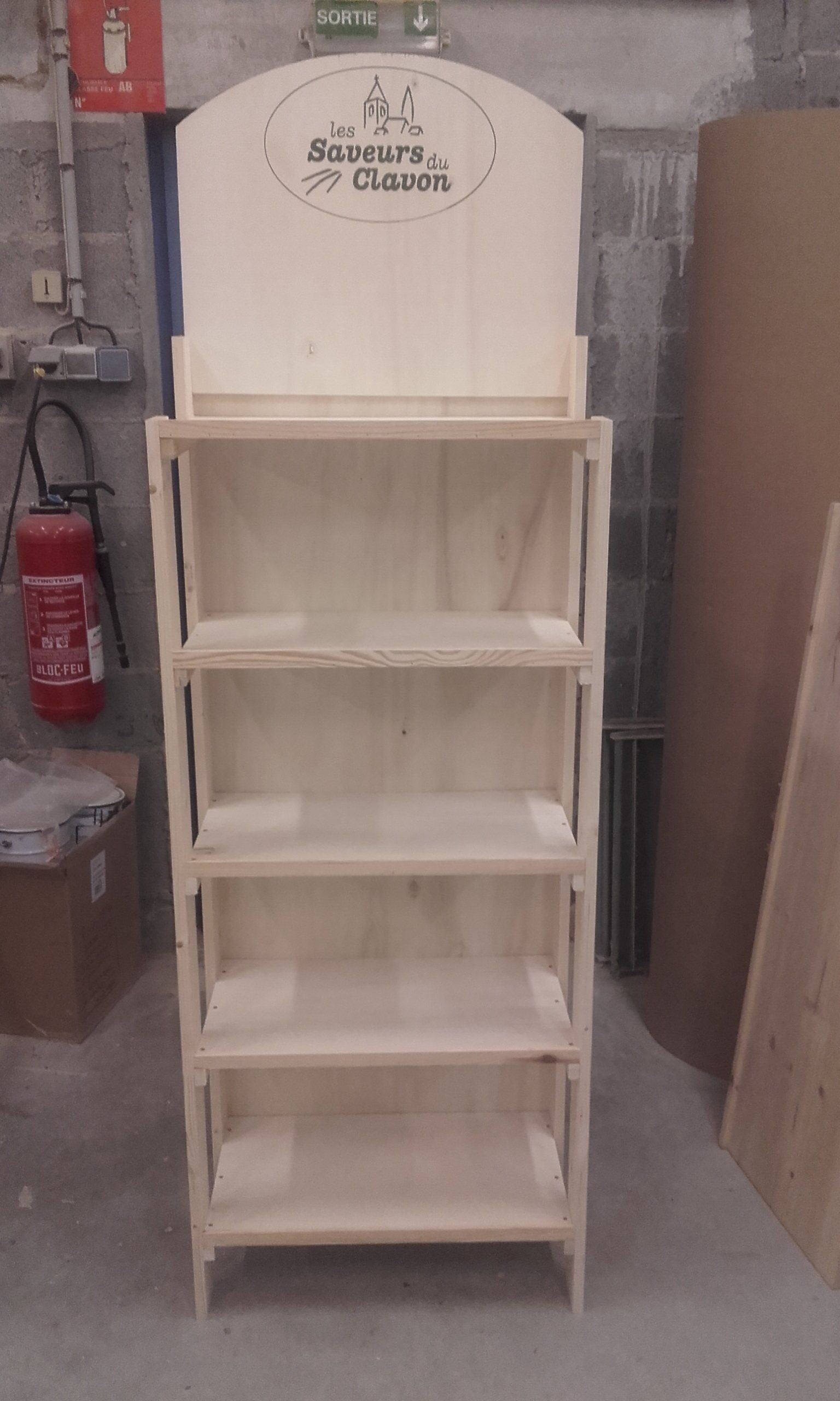 Photo d'un présentoir en bois avec le logo de la marque sur le dessus