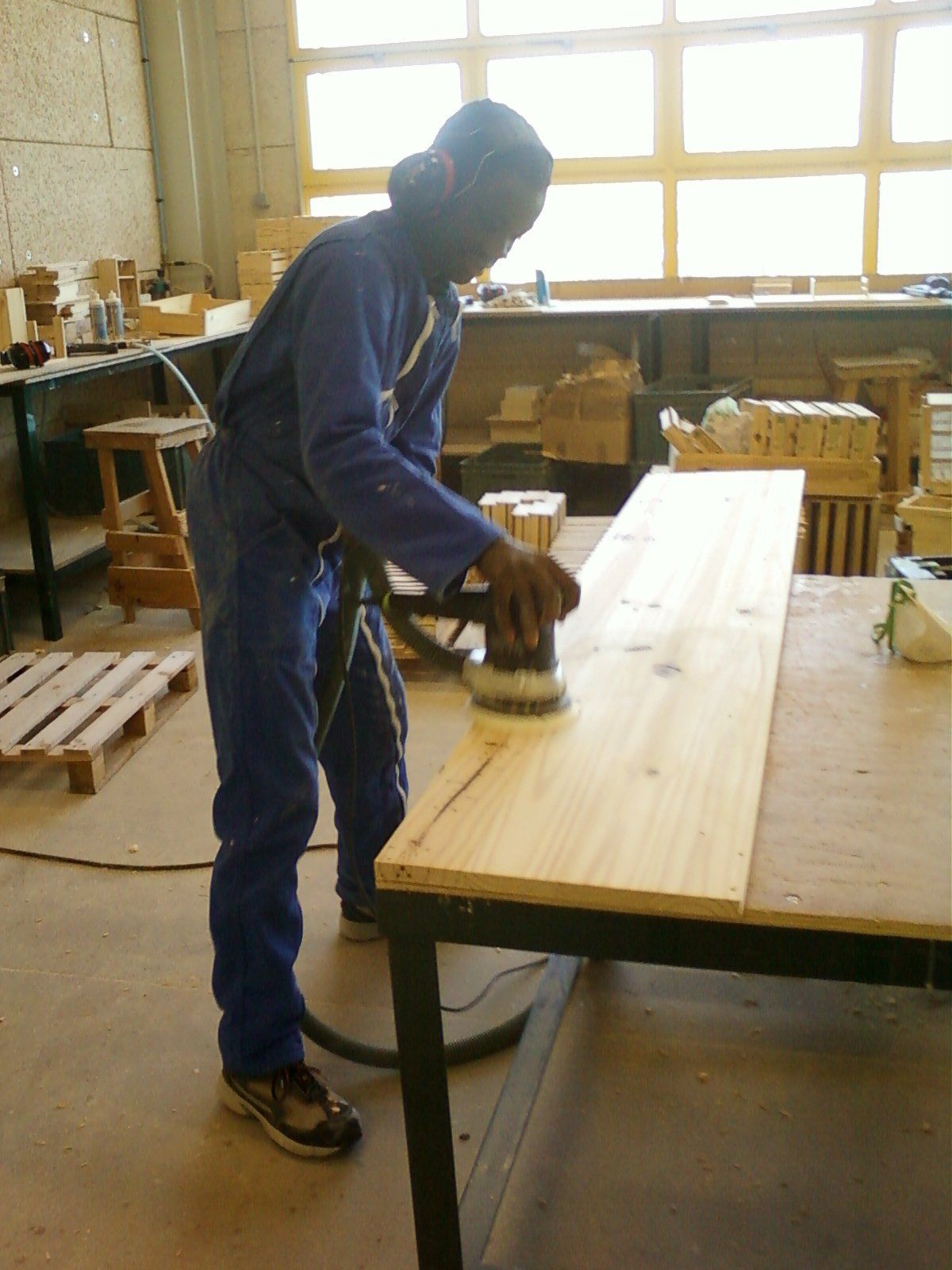 Photo d'un homme en train de poncer une planche