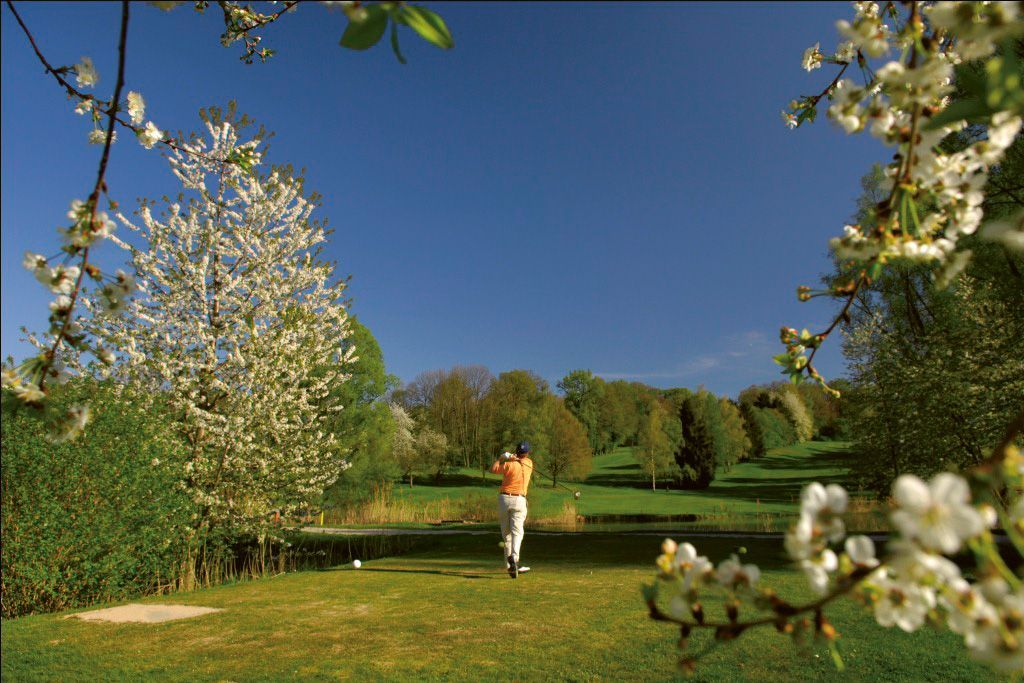 Ein Mann schwingt auf einem Golfplatz einen Golfschläger.