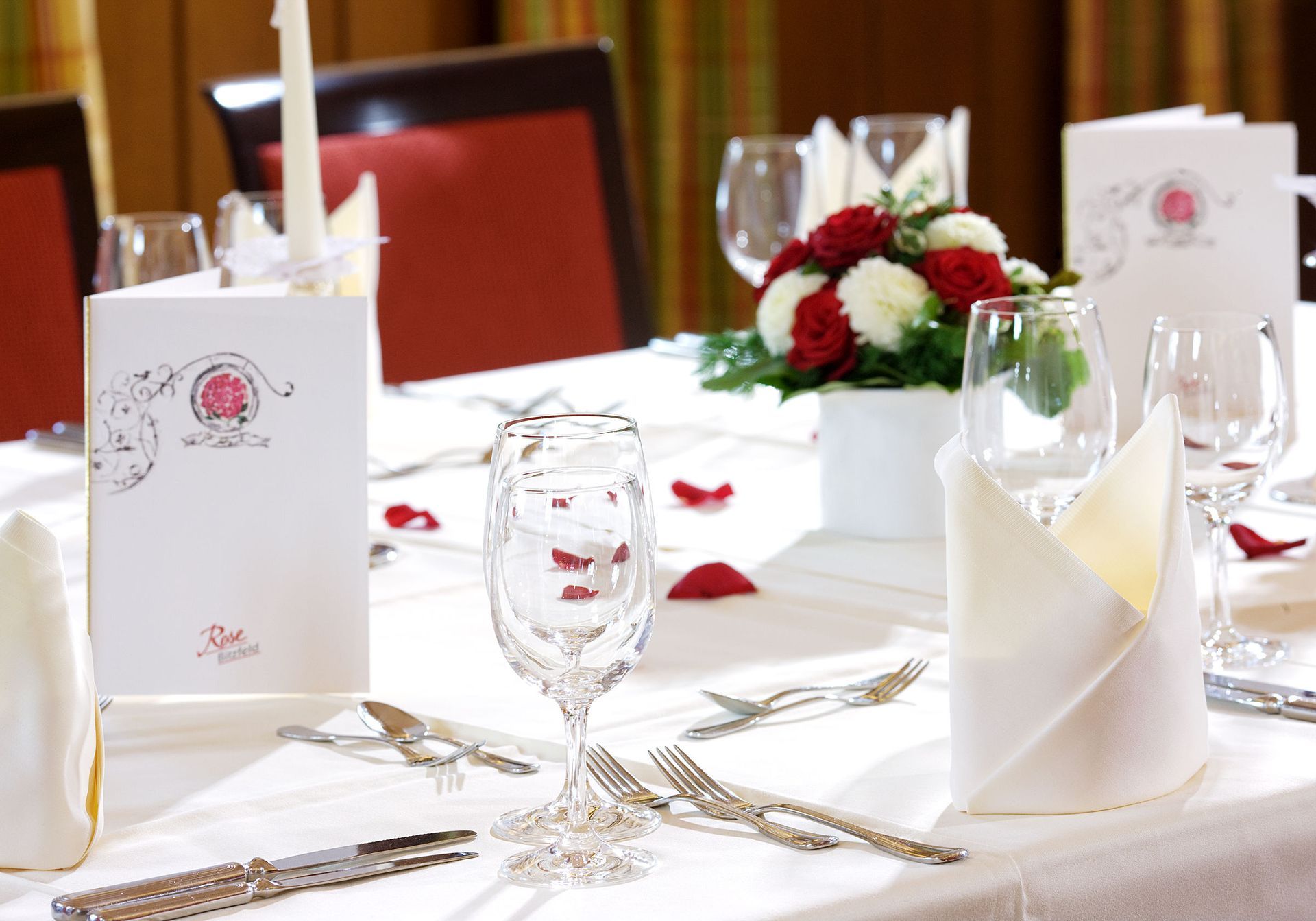 Ein gedeckter Tisch mit Gläsern und Besteck. Dazu noch eine Speisekarte.