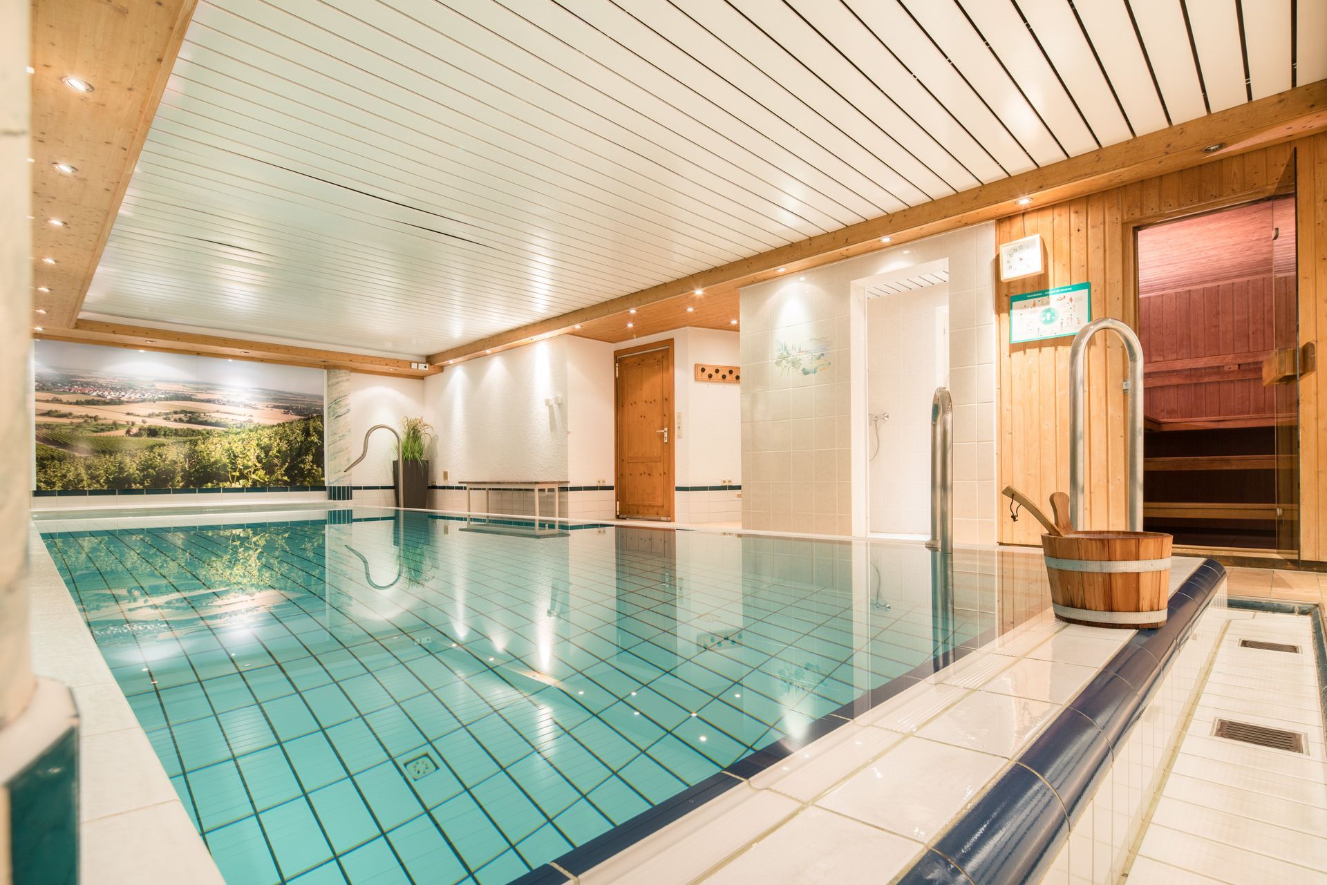 Ein großes Hallenbad mit Sauna im Hintergrund.