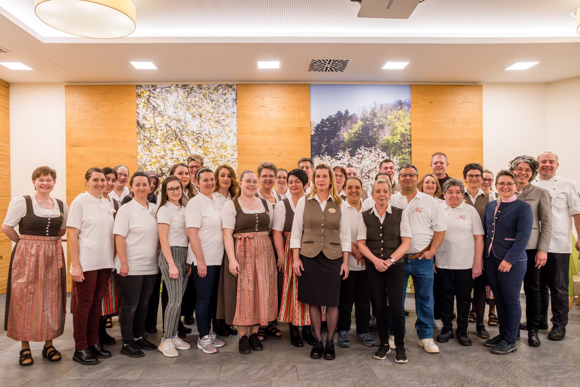 Eine große Gruppe von Menschen posiert in einem Raum für ein Foto. Sie sind das Team des Hotels.