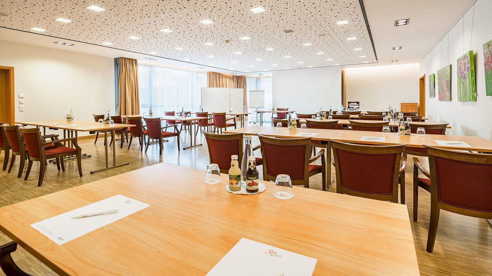 Ein großer Konferenzraum mit Tischen und Stühlen, die für eine Besprechung aufgestellt sind.